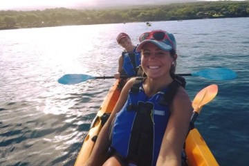 a woman standing next to a body of water